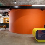 orange wall and entrance counter in creative agency office interior